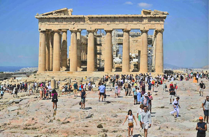 Turistas caminan frente al Partenón durante su visita al sitio arqueológico de la Acrópolis en Atenas. Foto Afp : Archivo.png